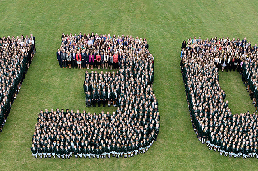 Aerial group photograph with pupils standing in shape of the numbers &quot;130&quot;